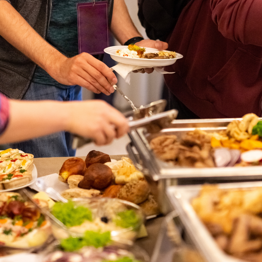 A buffet table of nourish bowl ingredients, grains, salads, and jacket potatoes with vibrant toppings.